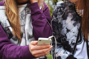 dos chicas escuchan música compartiendo auriculares
